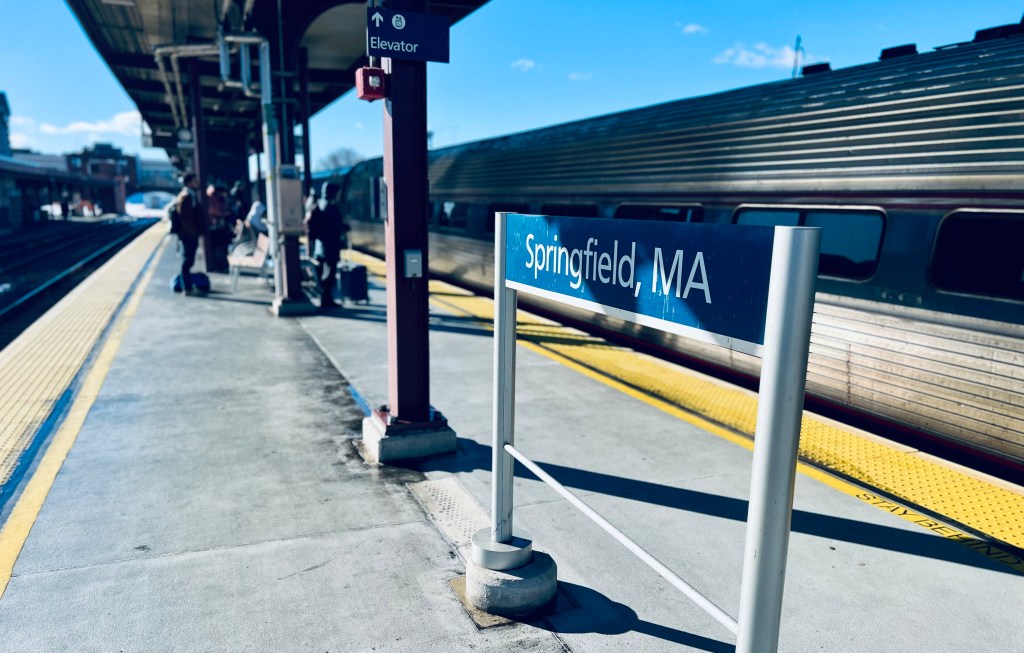 On a train platform, a sign reads "Springfield, MA."