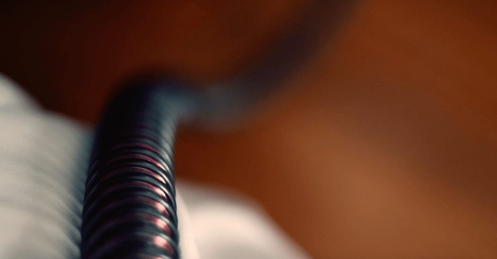 A breathing tube extends from a CPAP machine.